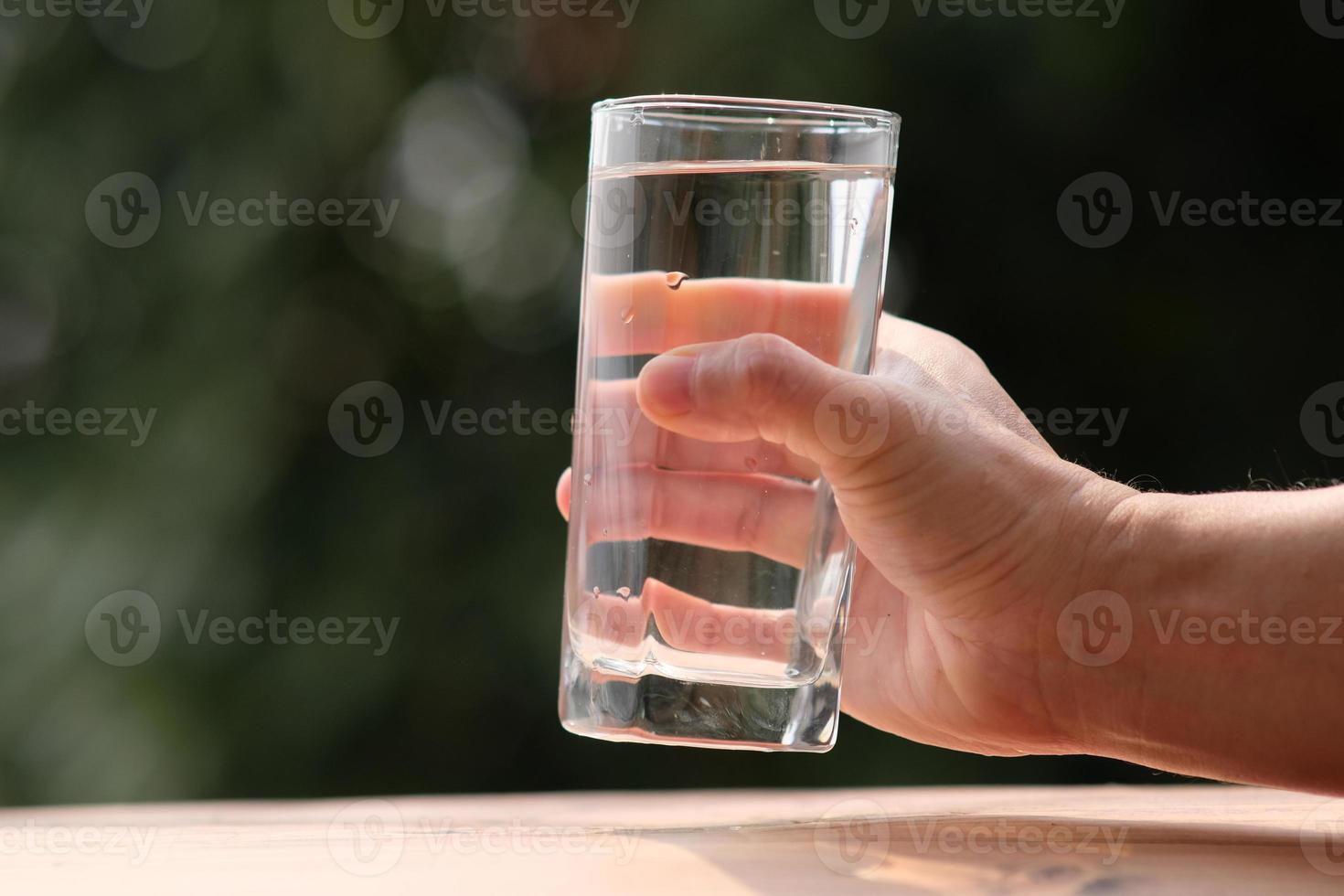 Agua potable mineral en la mesa de madera y agua en vidrio foto