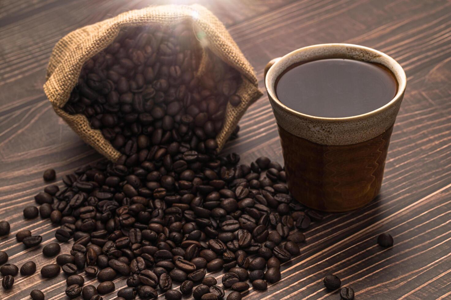 una taza de café y granos de café en una mesa de madera foto