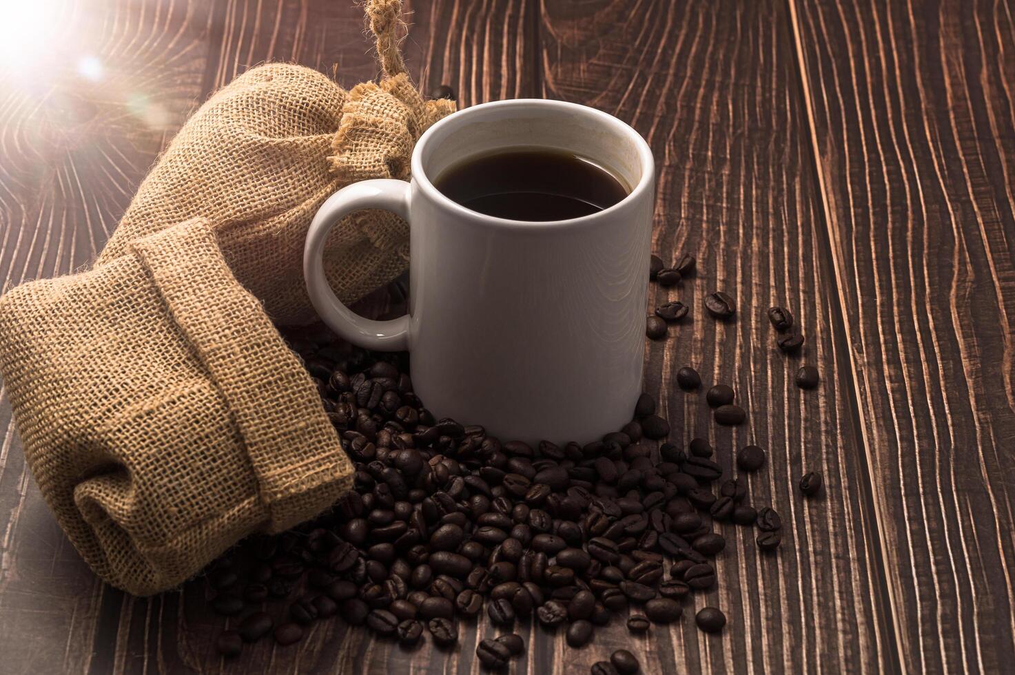 A coffee mug and coffee beans on a wooden table photo