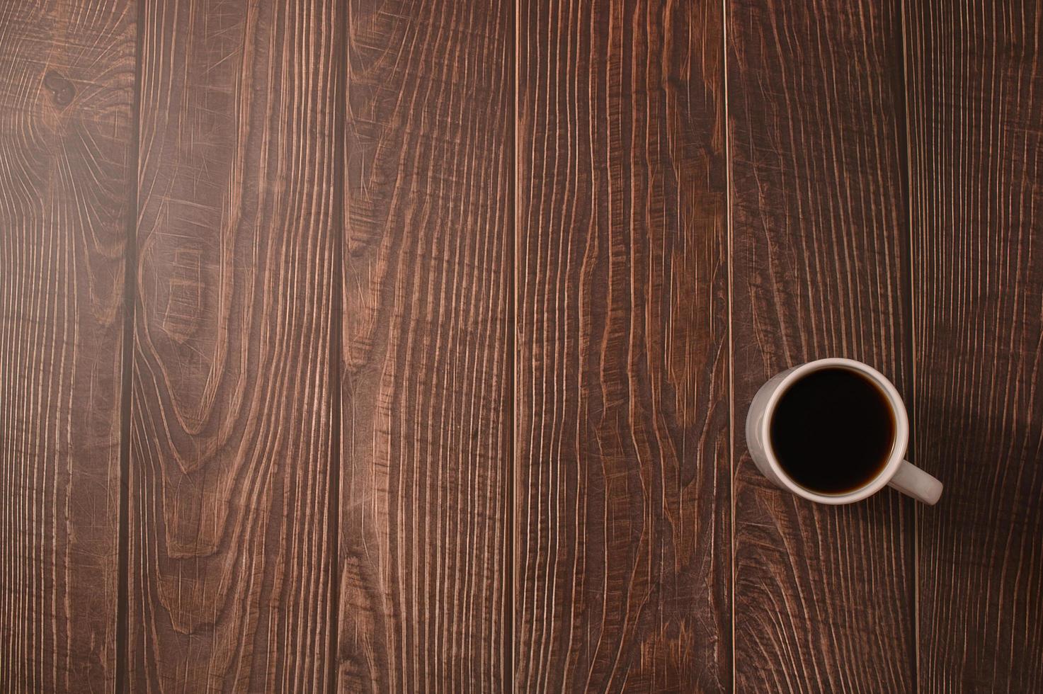 una taza de café en un escritorio de madera foto