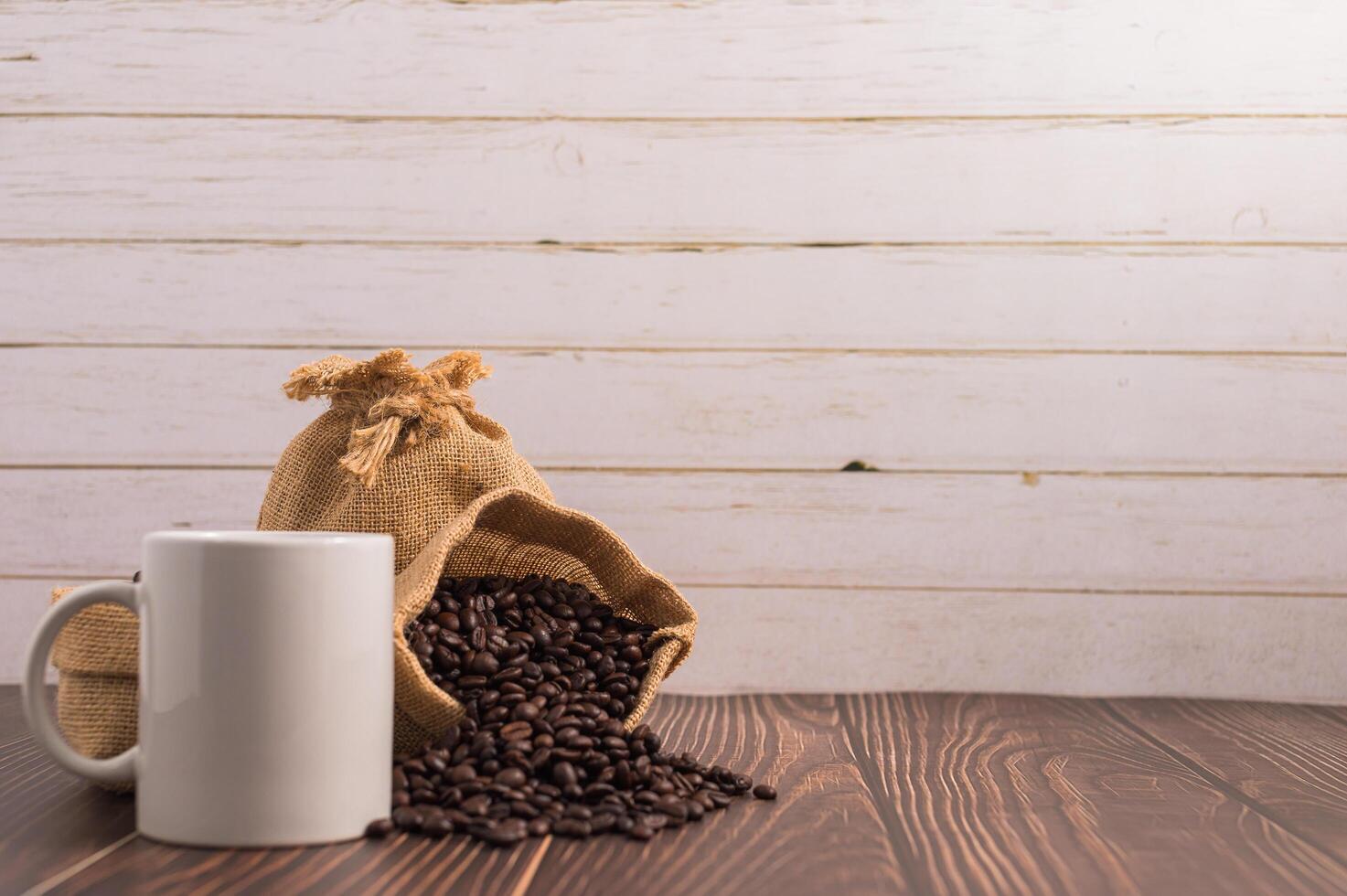 A coffee mug and bags of coffee beans on a wooden table photo