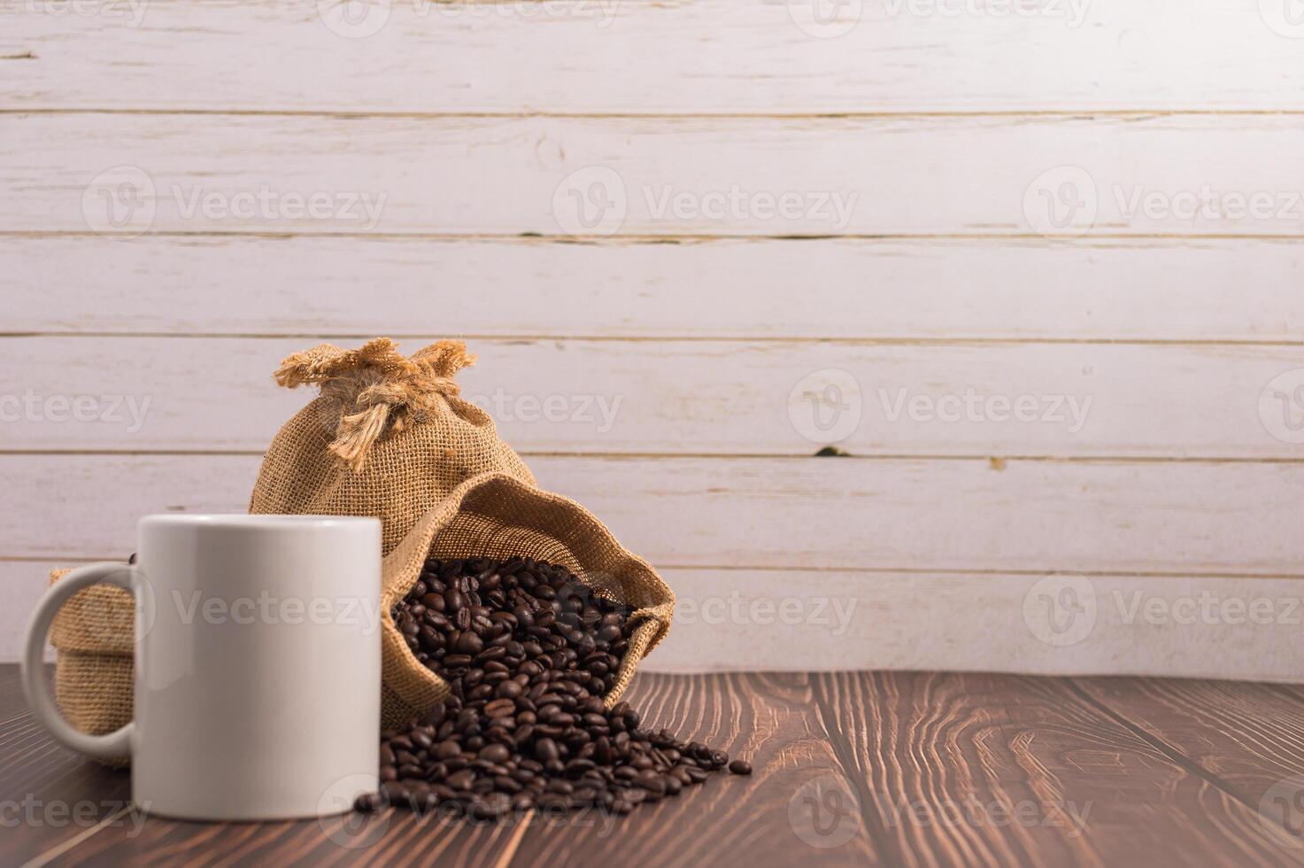 Coffee beans and coffee cup on wooden table photo