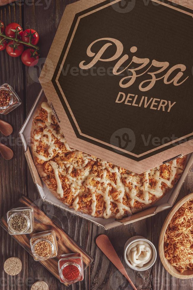 Brazilian pizza with mozzarella, chicken, catupiry and oregano in a delivery box photo