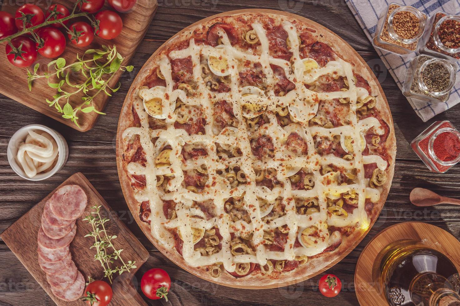 pizza con mozzarella, chorizo calabrese, huevos, catupiry, aceituna y orégano foto