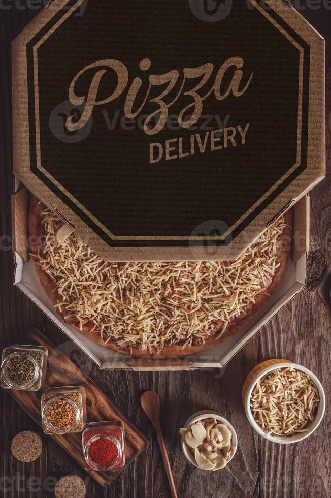 Pizza with mozzarella, beef stroganoff and potato sticks in a delivery box photo