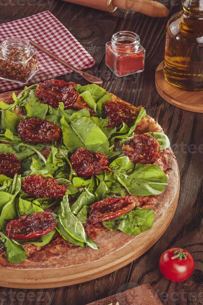 pizza brasileña con salsa de tomate, mozzarella, rúcula, tomates secos y orégano foto