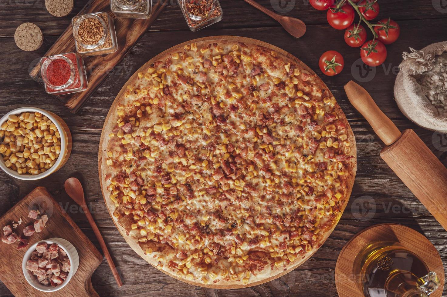 pizza con mozzarella, maíz, tocino y orégano foto