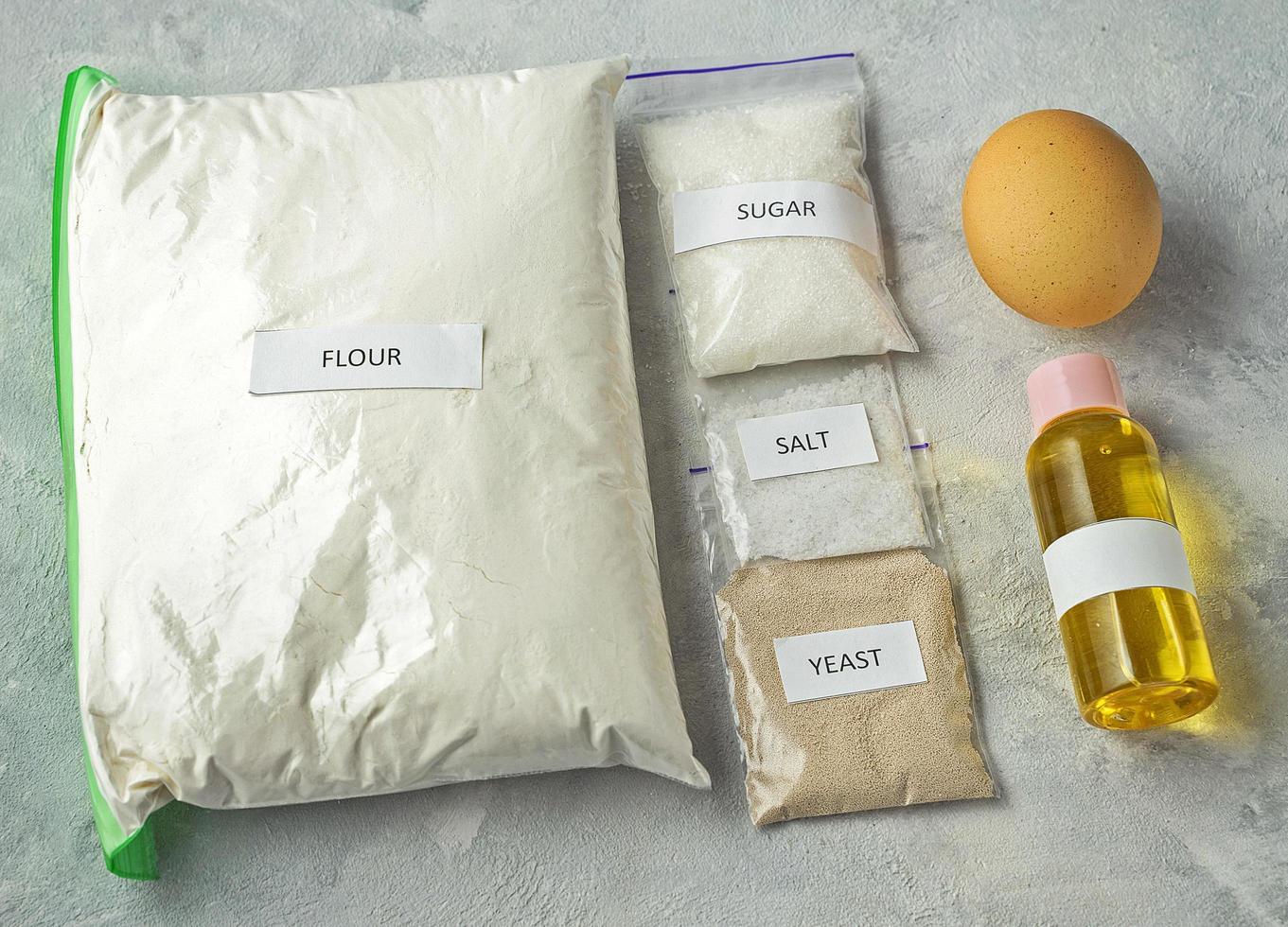 A set of ingredients for baking homemade bread, including wholewheat flour, salt, sugar, sunflower or olive oil, and yeast photo
