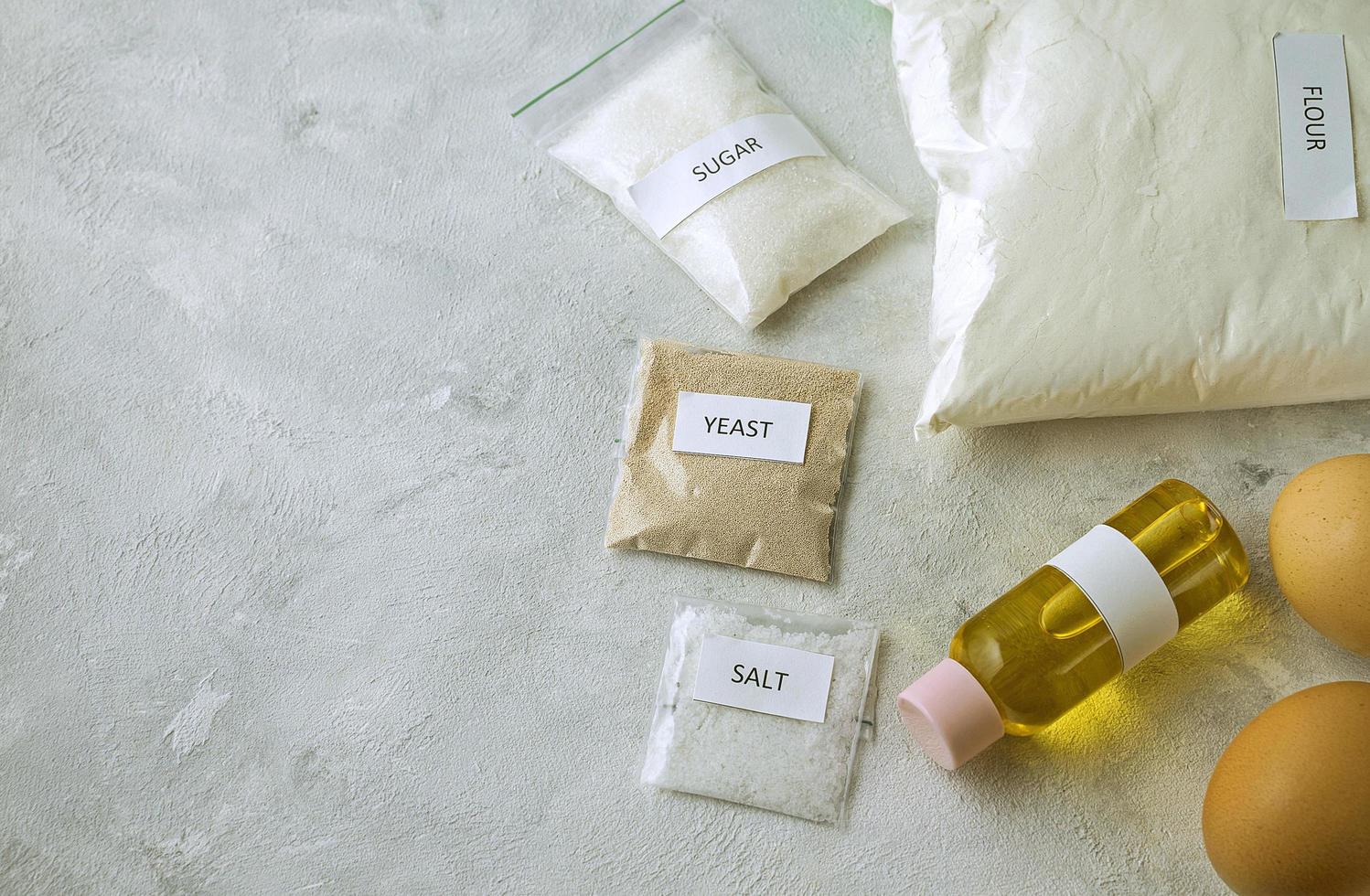 A set of ingredients for baking homemade bread, including wholewheat flour, salt, sugar, sunflower or olive oil, and yeast photo