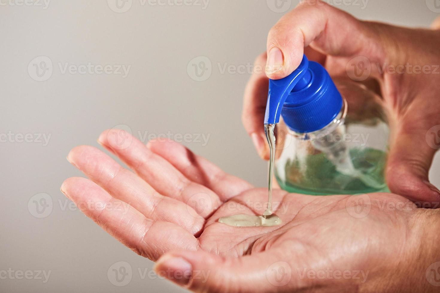 Cleansing hands with hand sanitizer gel photo