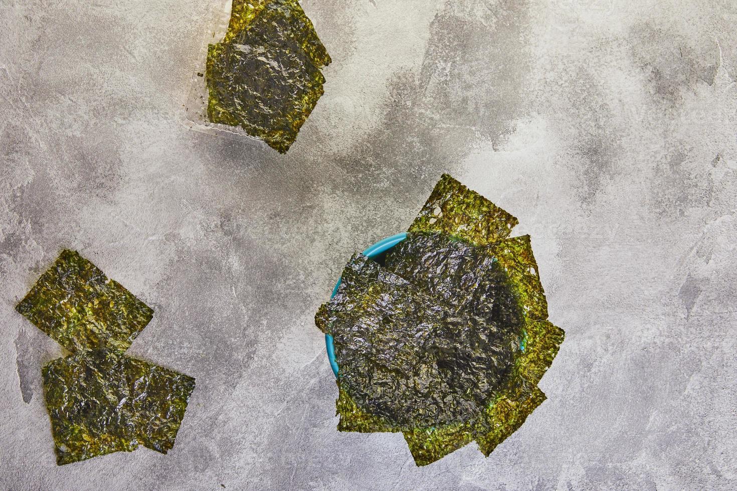 Crispy nori seaweed in a blue bowl on a gray background photo