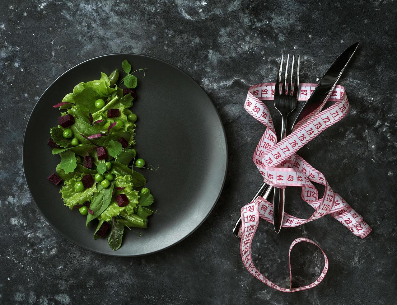 Ensalada dietética de hojas de lechuga, espinacas y guisantes sobre un fondo oscuro foto