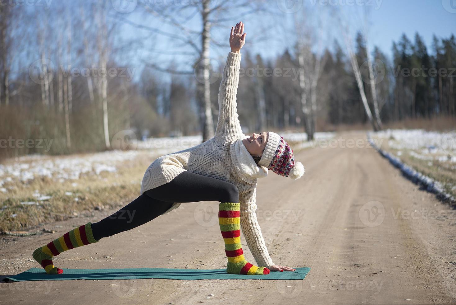 A young athletic woman performs yoga and meditation exercises outdoors photo