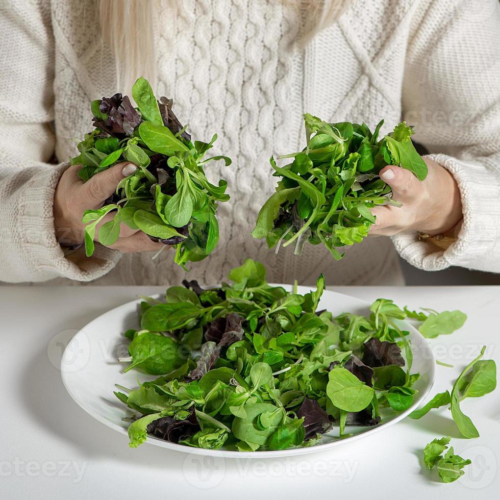 Close-up of woman holding green lettuce leaves, healthy concept photo