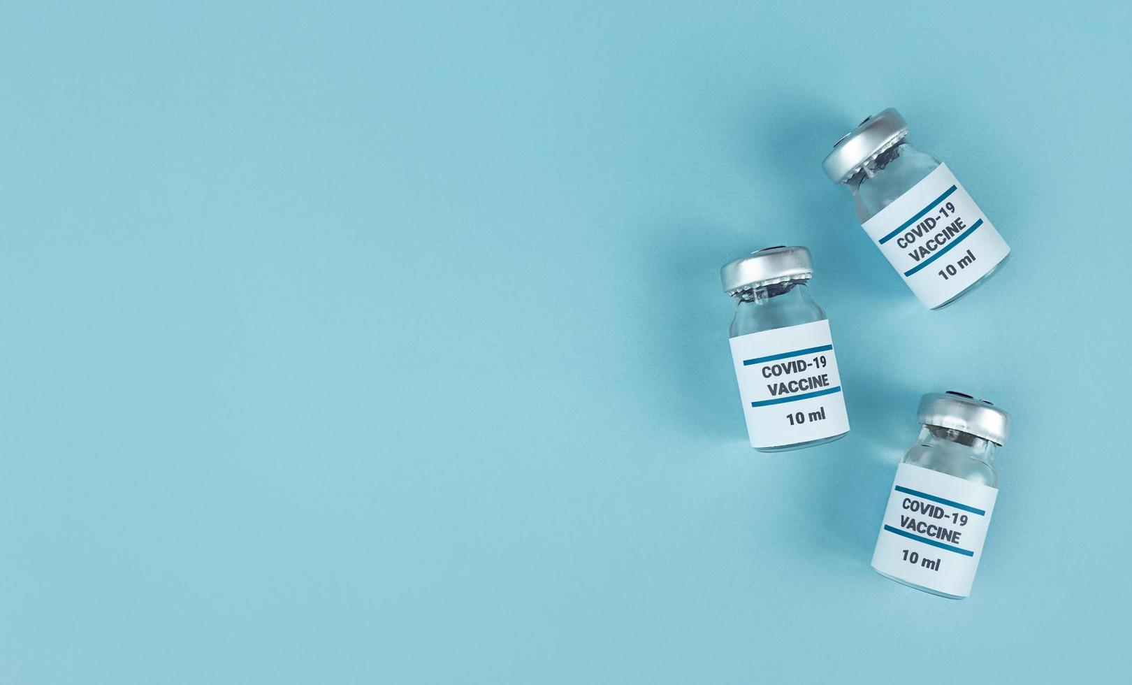 Medicine bottles with Covid 19 vaccine on a blue background photo