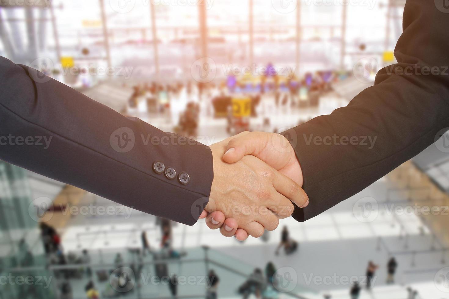 apretón de manos entre dos hombres de negocios en un aeropuerto, concepto de negocio foto