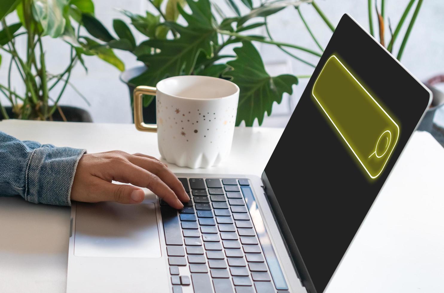 A hand using a laptop computer searching for information in the internet with a search box icon photo