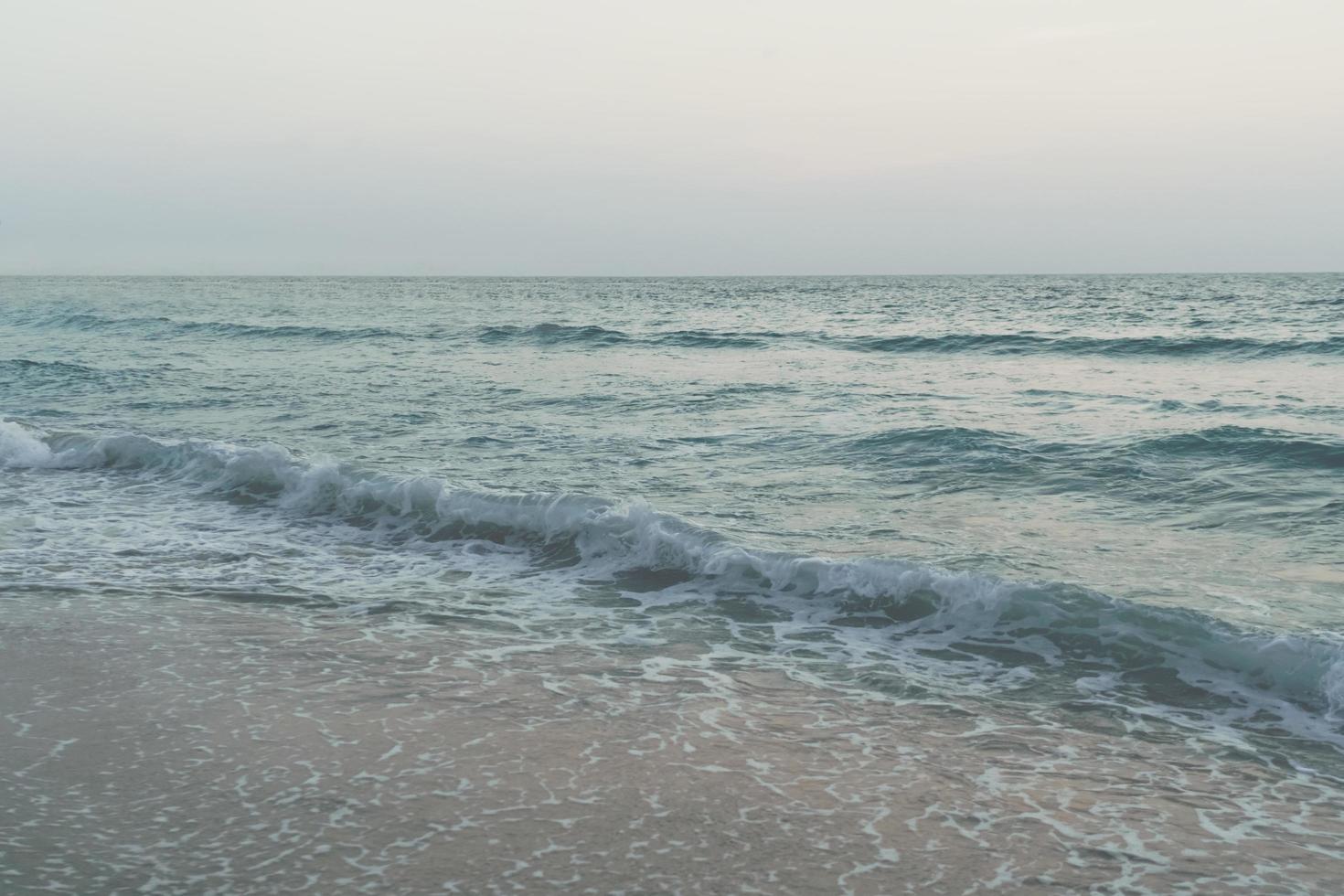 Vintage fade tone of ocean sea waves at the beach during summer photo