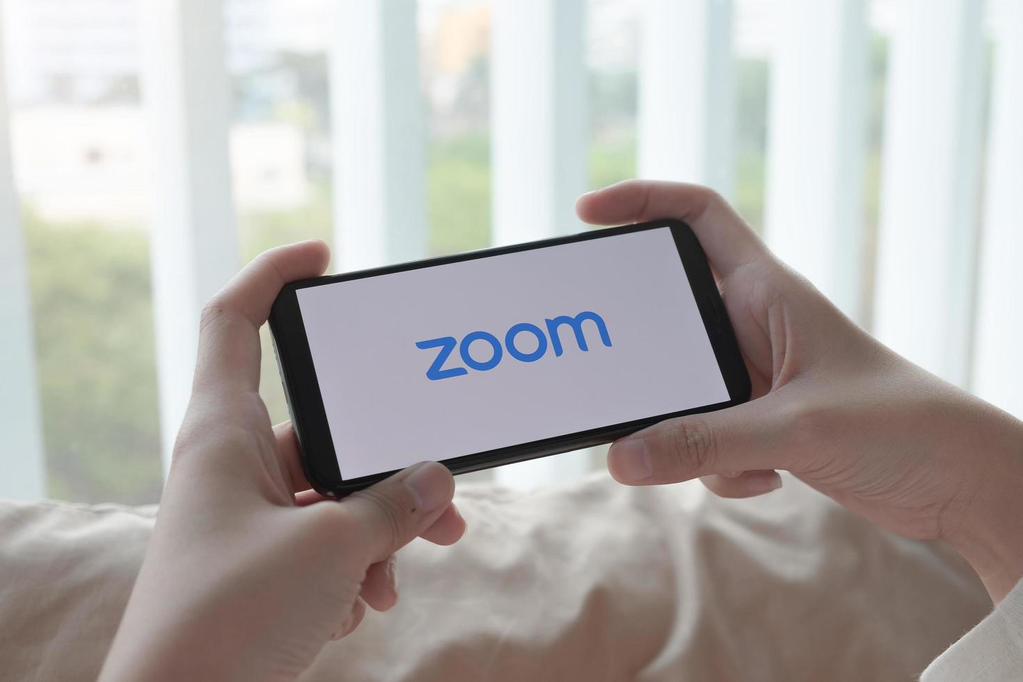 Chiang Mai, Thailand, Mar, 21, 2021 - Person connecting on Zoom on a smartphone photo