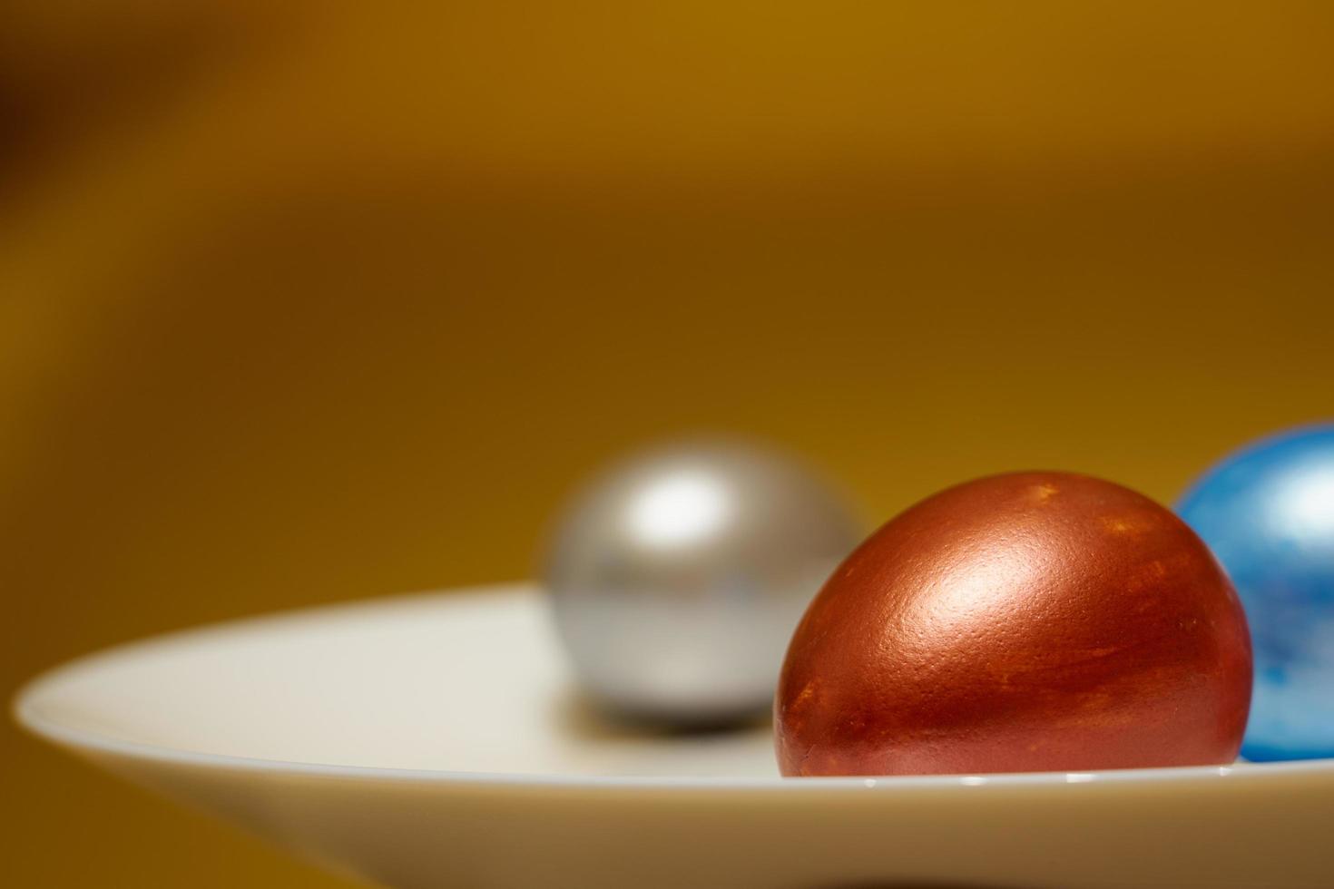 Pearly-colored Easter eggs in an egg carton on a golden background photo