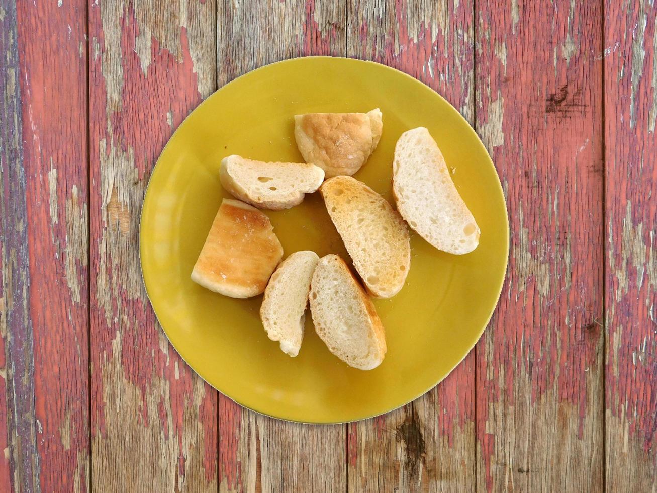 Sliced bread on a yellow plate on wooden table background photo