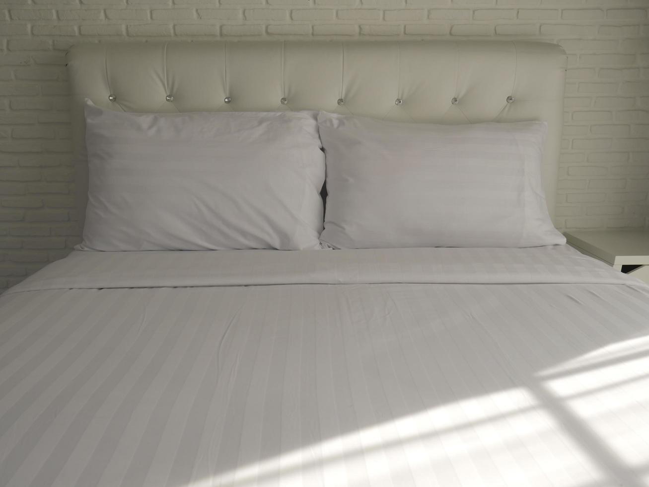 Double bed with white pillows and comforter photo
