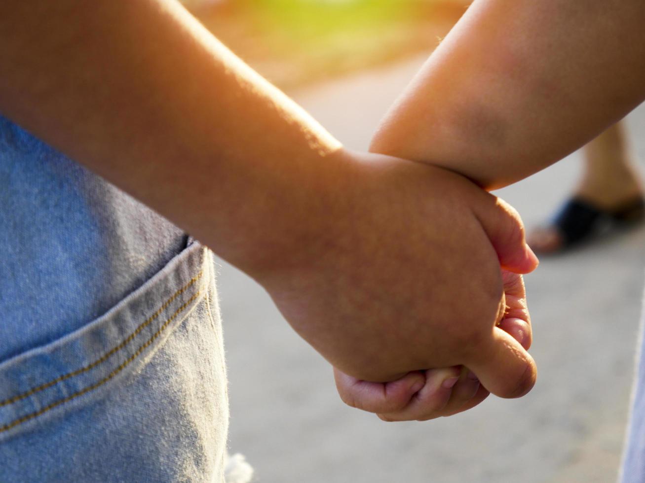 Two children walking hand in hand photo