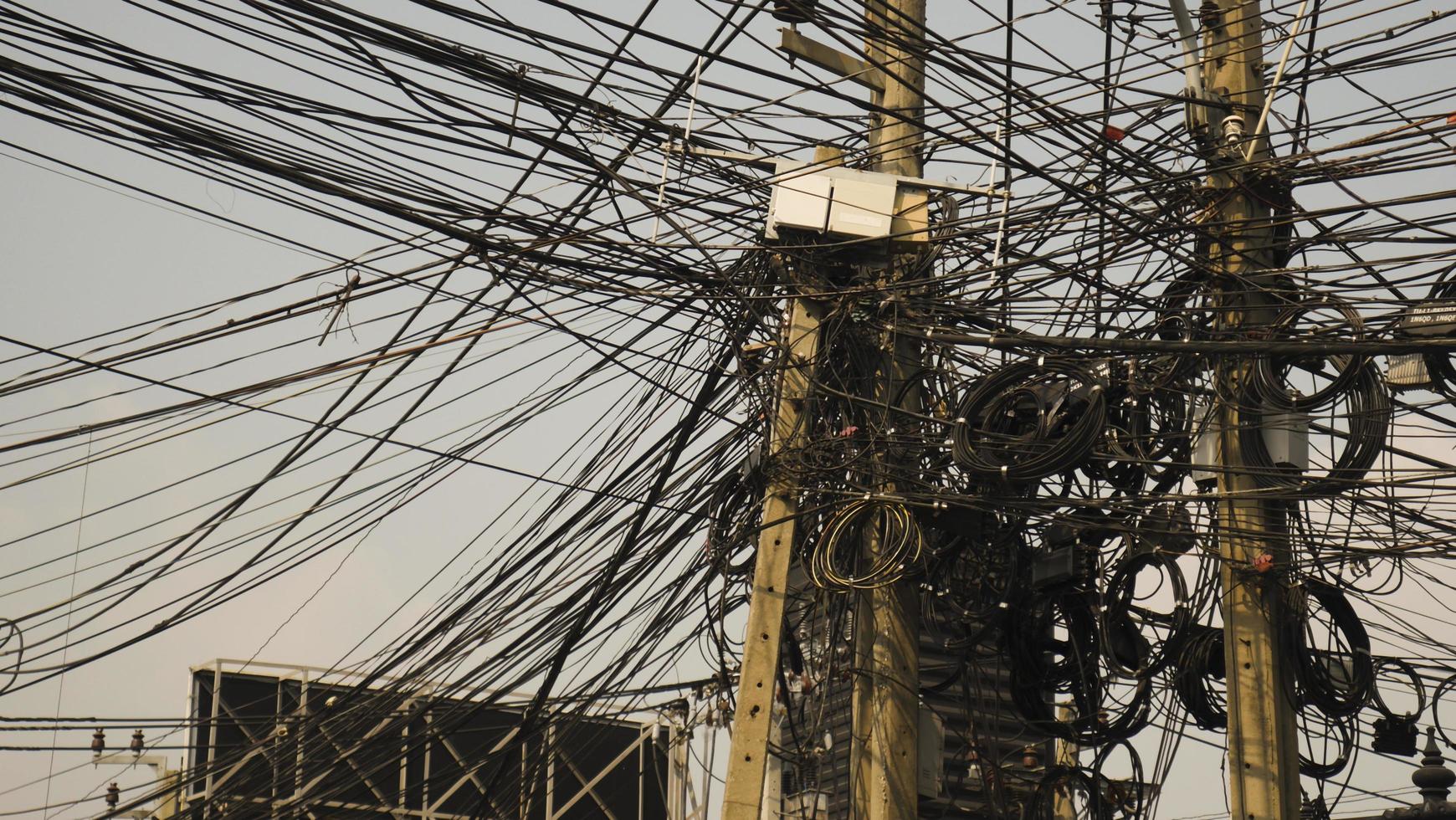 líneas de comunicación que parecen desordenadas en postes eléctricos foto