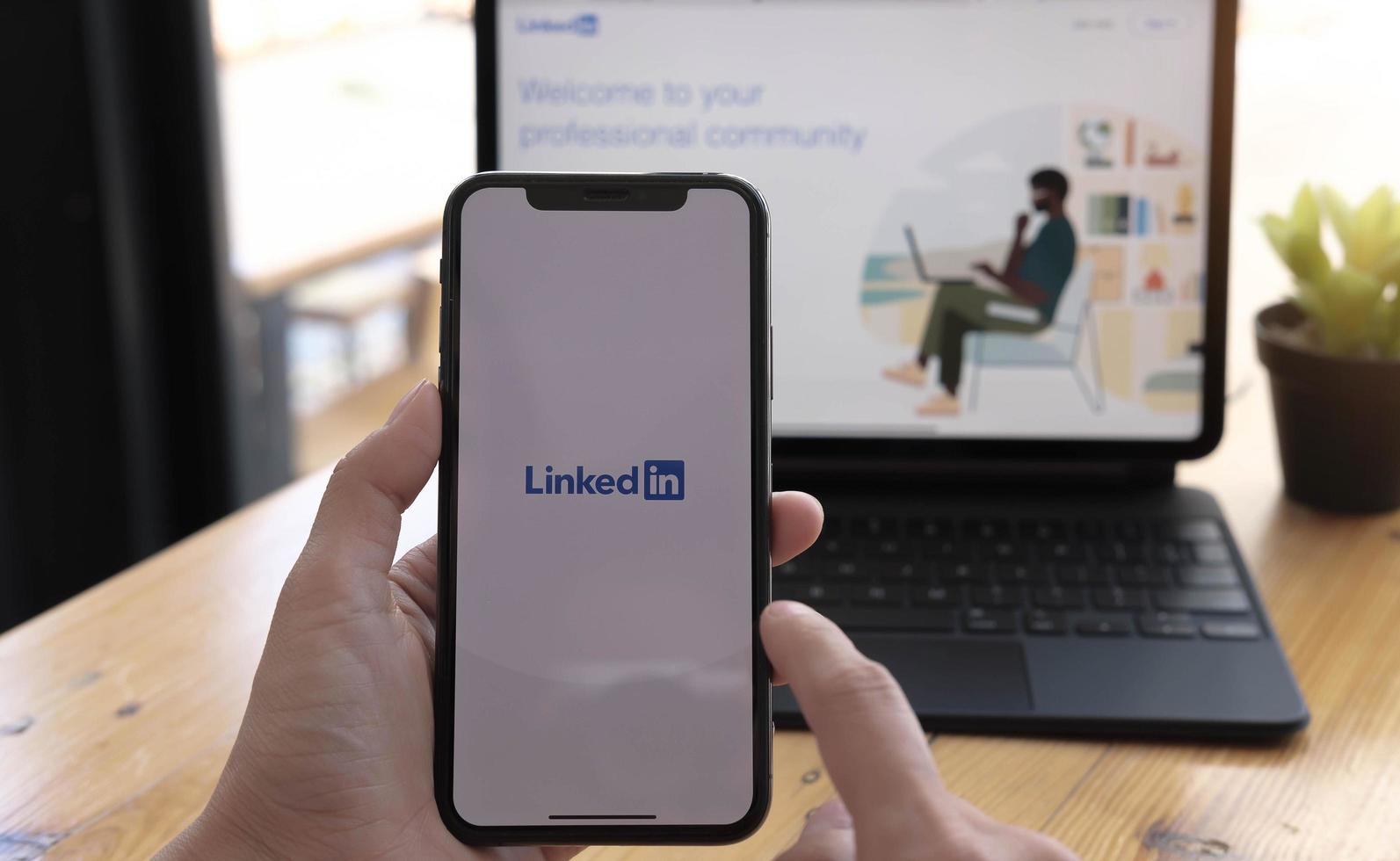 chiang mai, tailandia, 21 de marzo de 2021 - persona que usa linkedin en teléfono y computadora foto