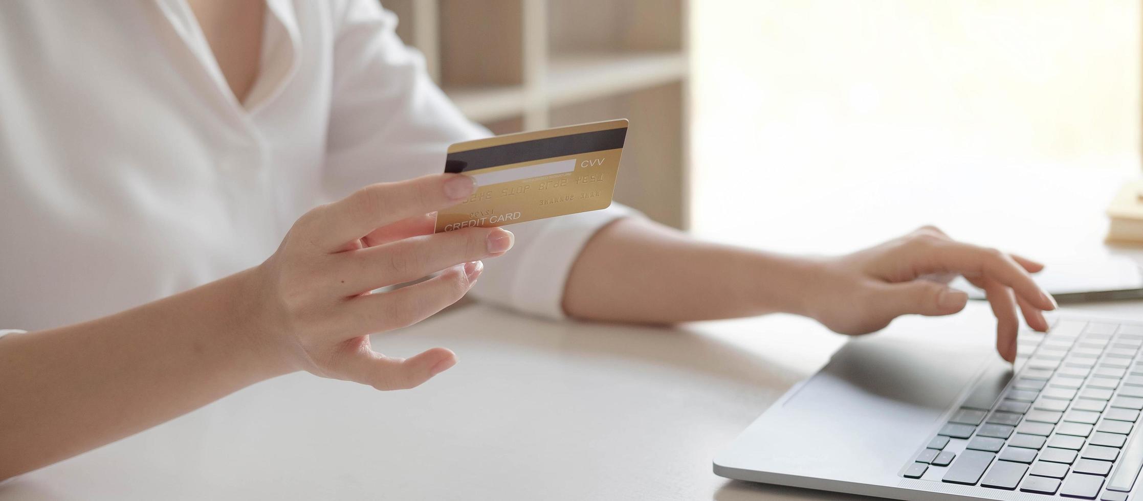 Hands holding a credit card and typing photo