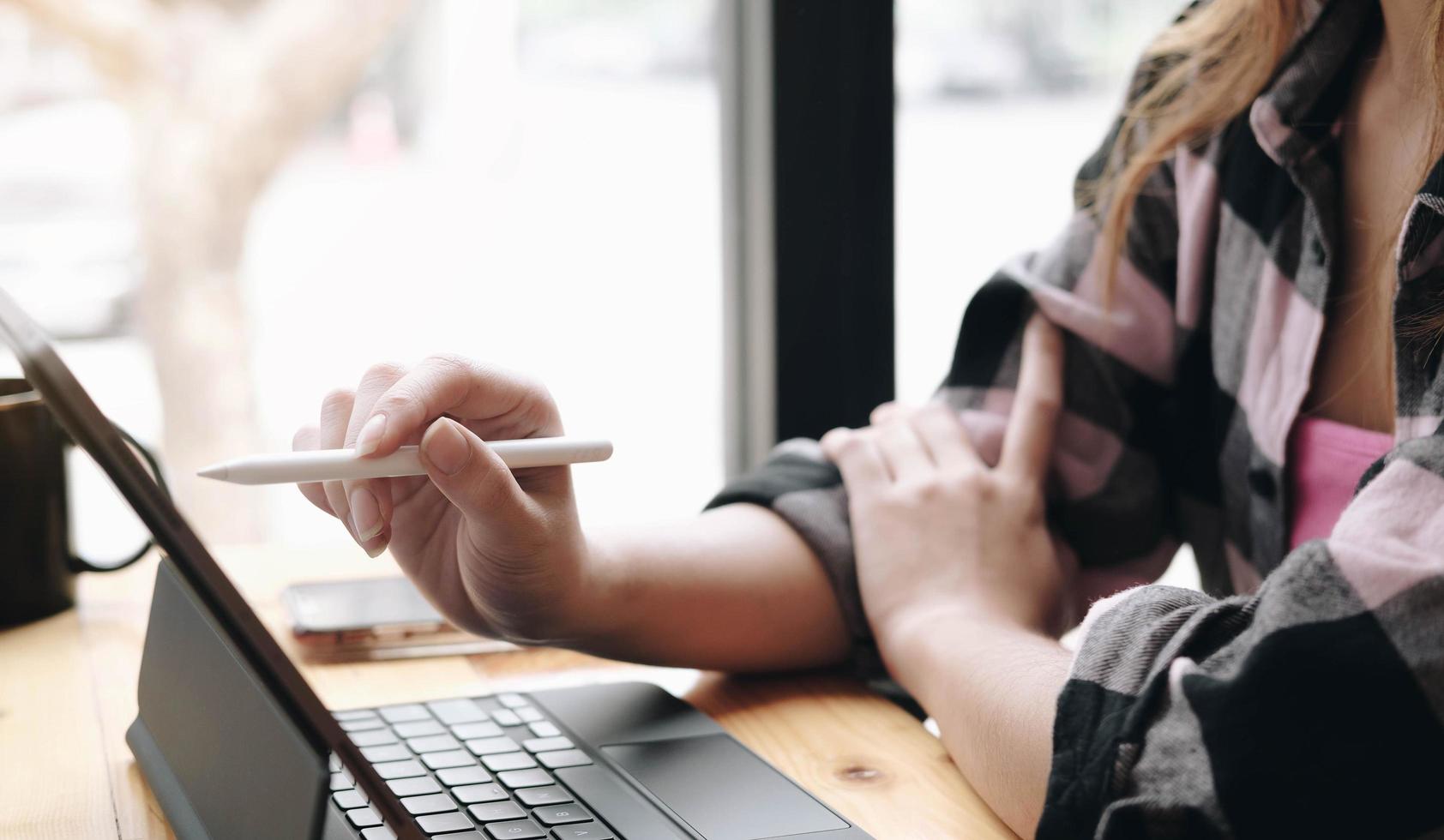 Close-up of a person using a stylus on a tablet photo