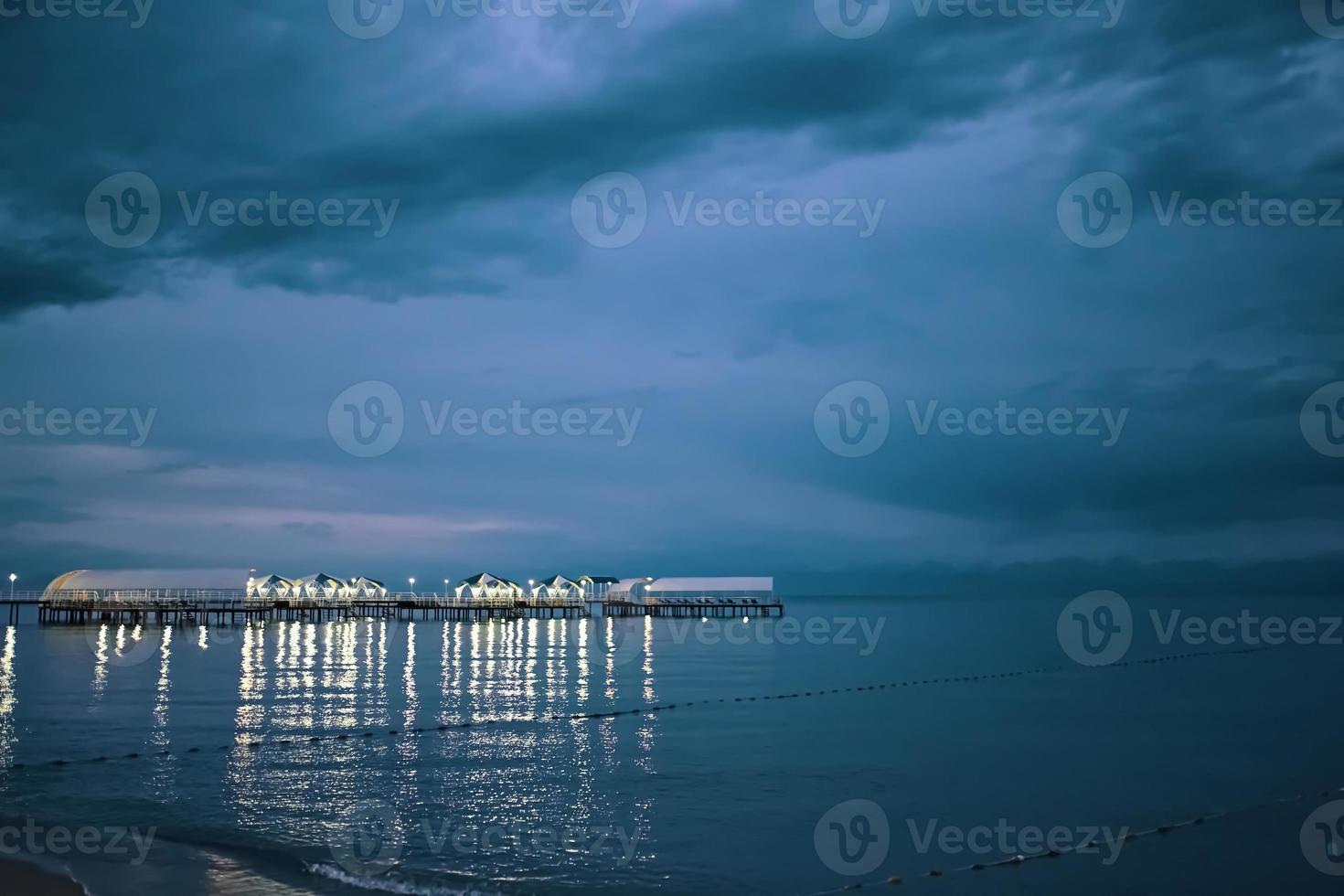 Twilight landscape of pier stretching out into sea photo