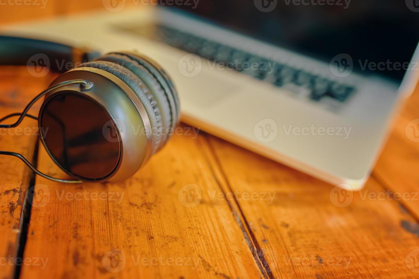 portátil y auriculares inalámbricos en la mesa de madera foto