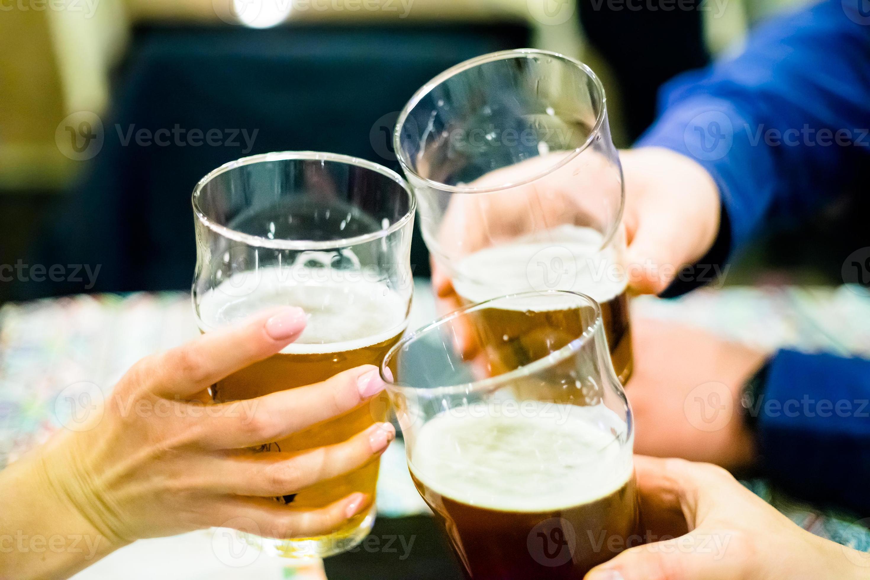 tres personas tintineando vasos de cerveza foto