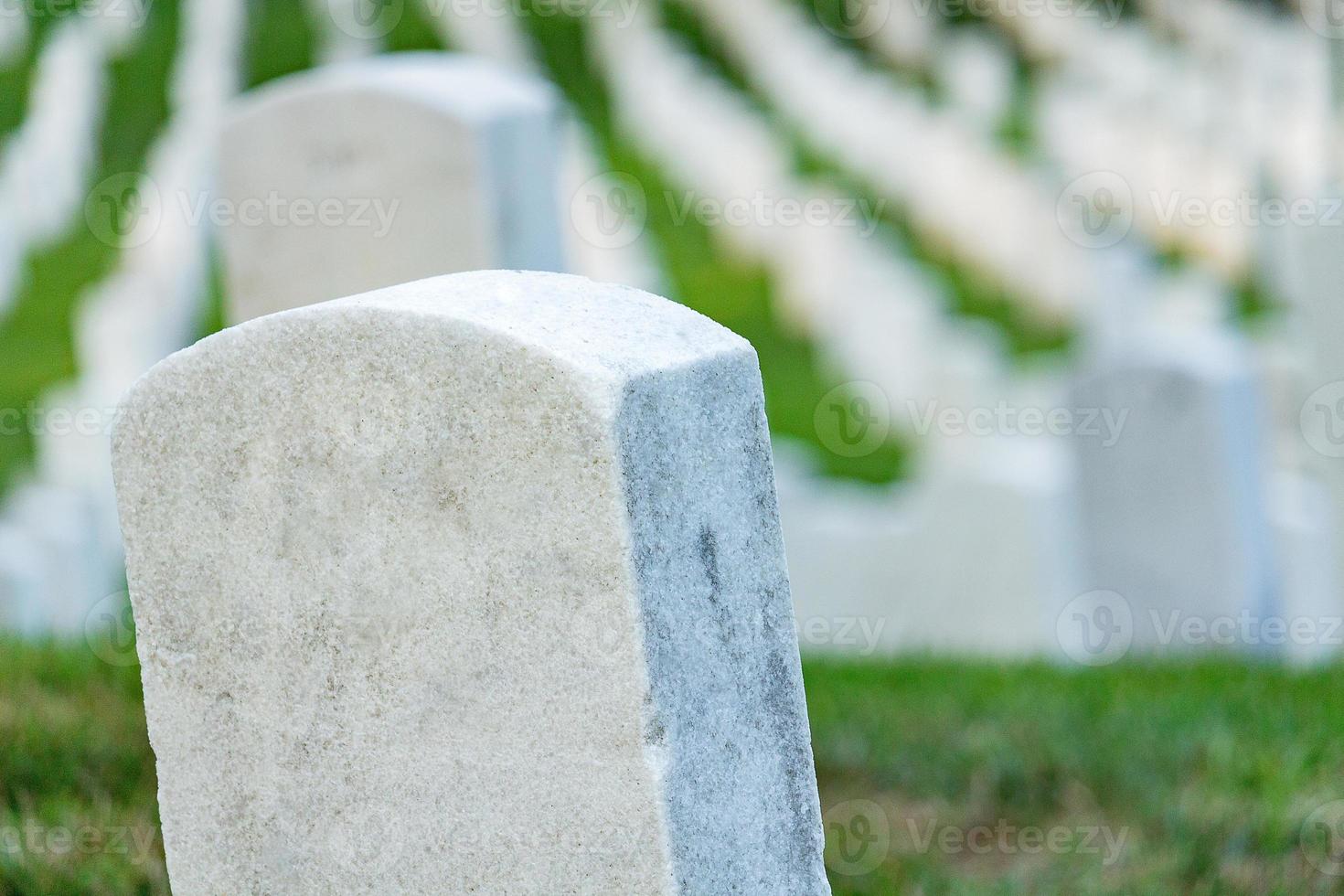 lápidas en un cementerio pacífico, enfoque selectivo en una piedra frontal. foto