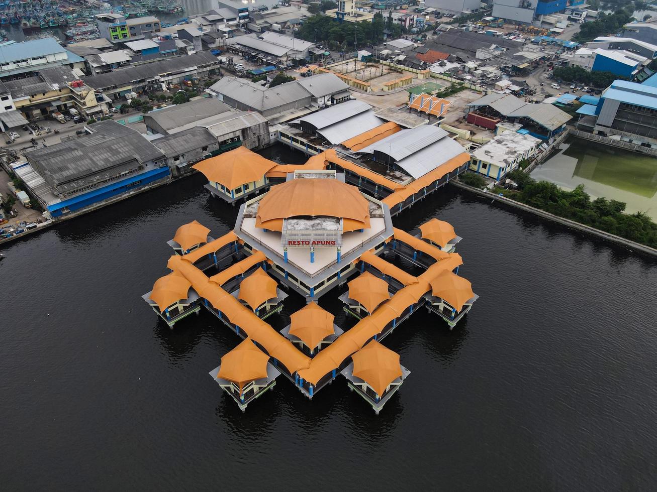 Jakarta, Indonesia 2021- Aerial drone view of Muara Angke beach with wooden boats leaning beside the pier photo