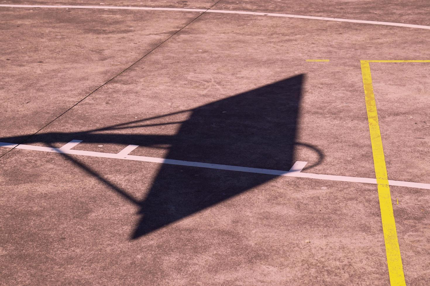 silueta de sombra de aro de baloncesto callejero en la cancha foto