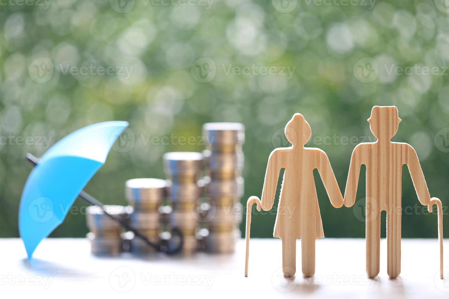 Couple cutout and stack of coins money on natural green background photo