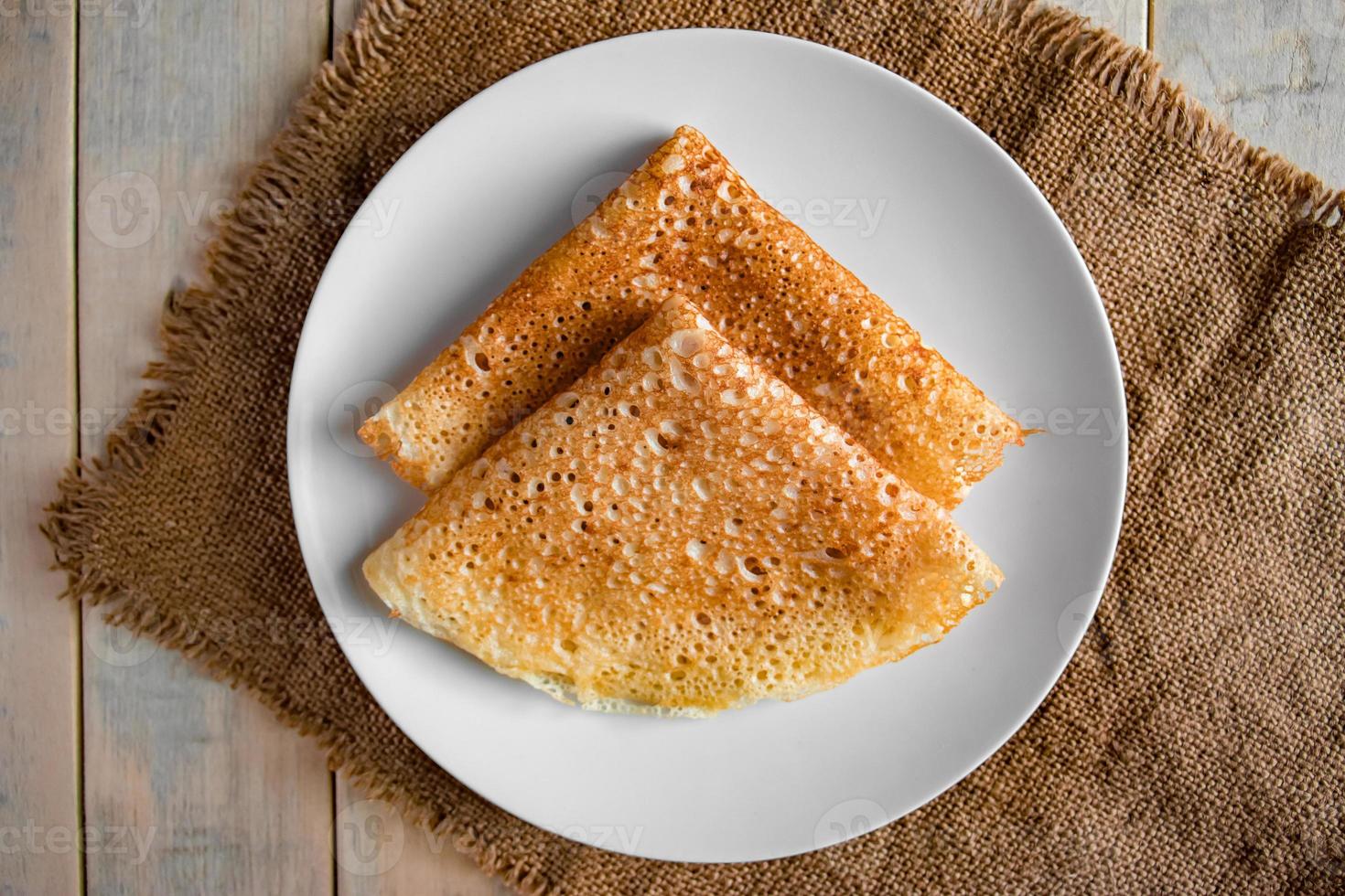 Pancakes on a white plate on a linen background photo