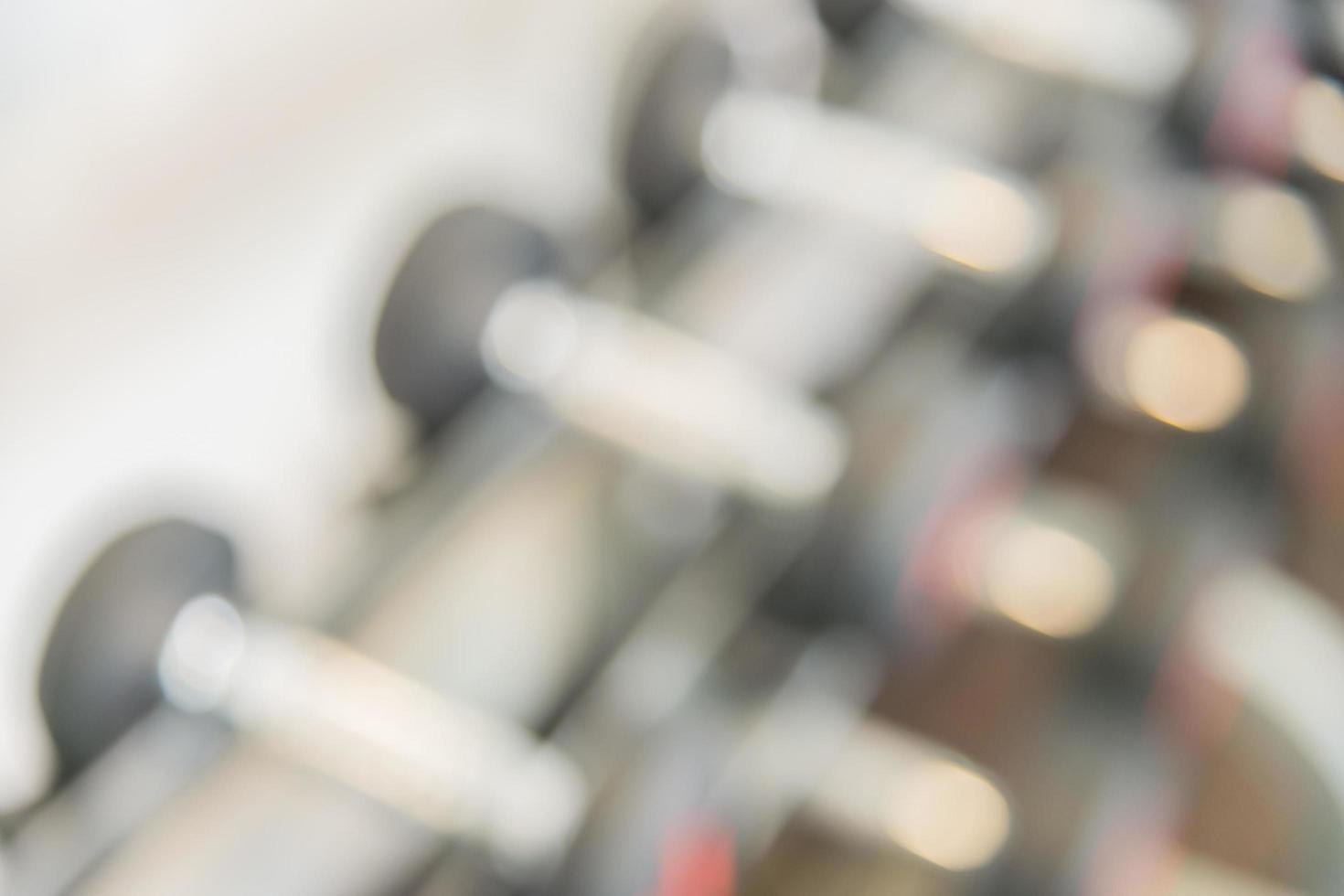 Blurred dumbbells in gym, background photo