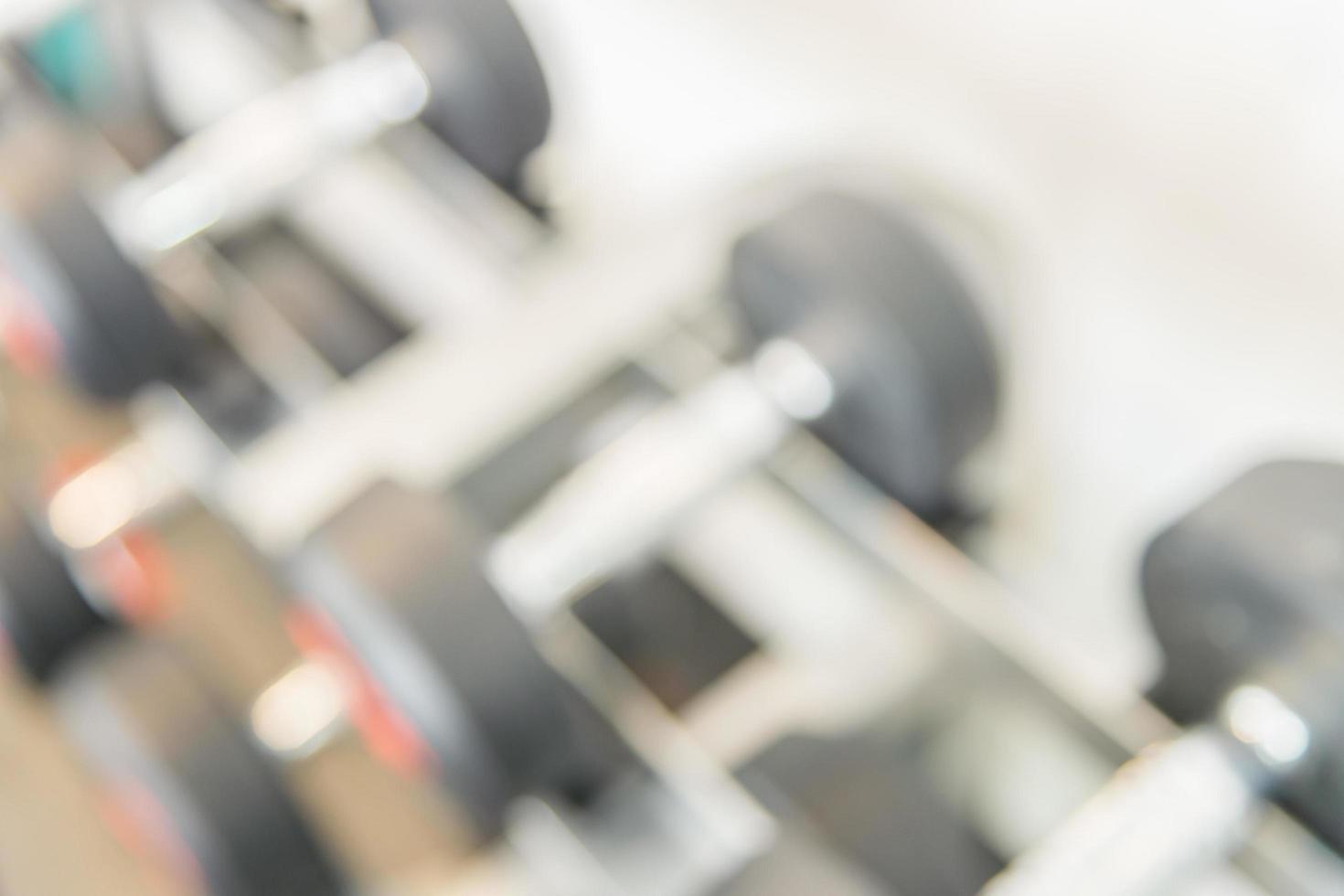 Blurred dumbbells in gym, background photo