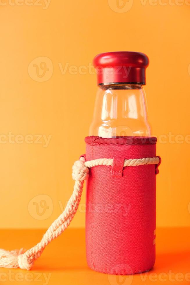 Empty milk glass bottle on orange background photo