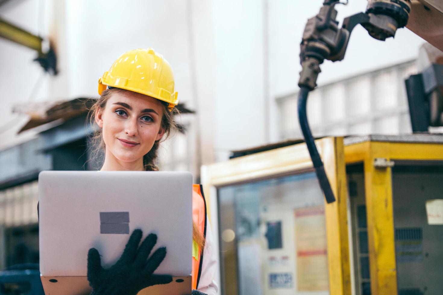 Woman in hard hat holding a laptop photo