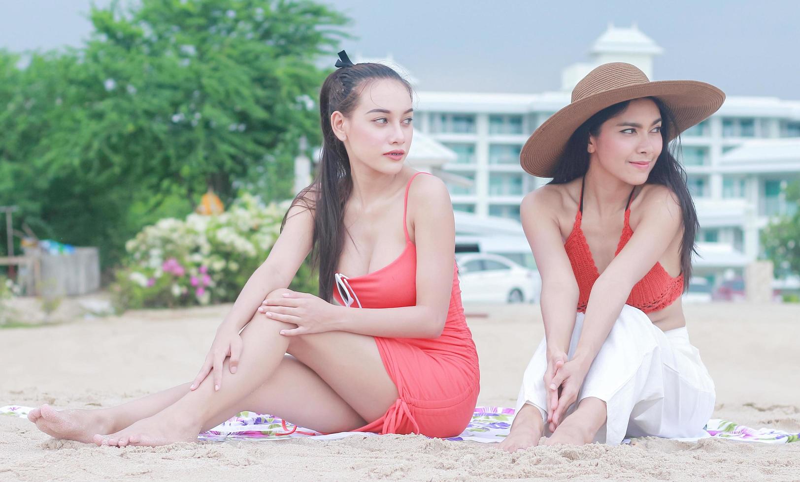dos hermosas mujeres felices sentadas en la playa foto