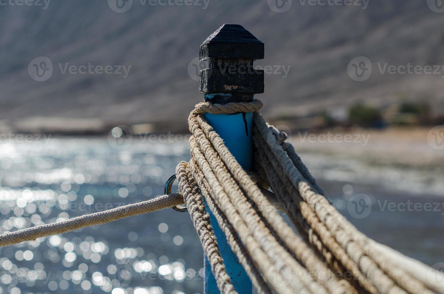 Ropes on a pole against the blue sea photo