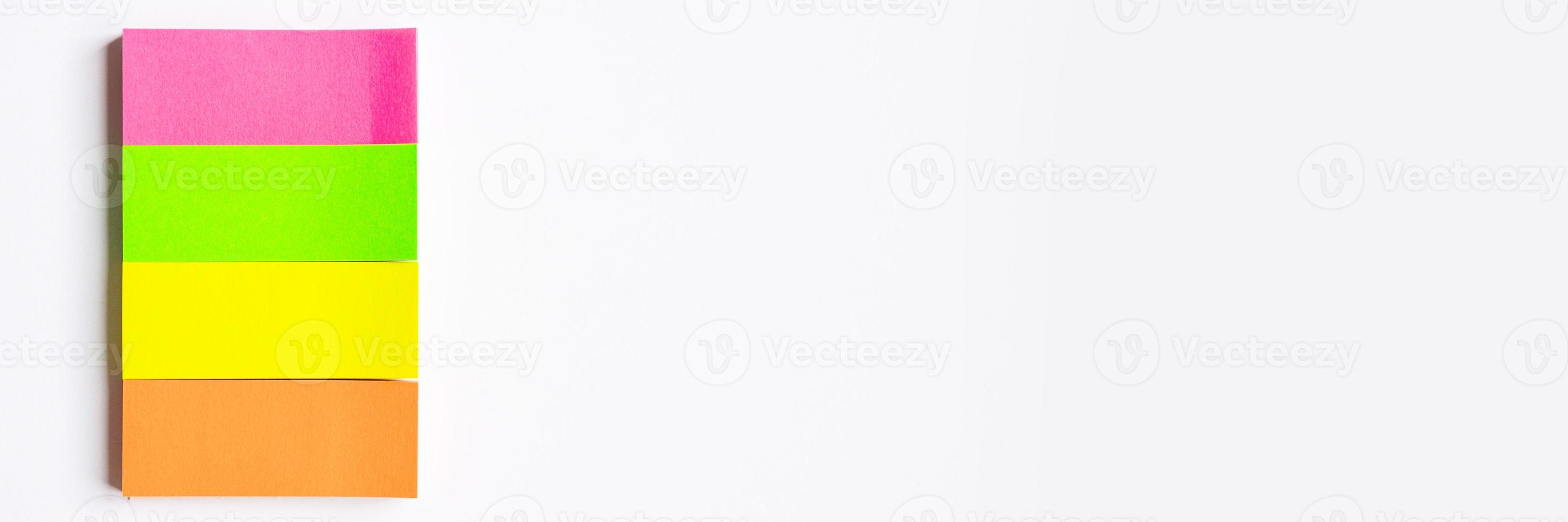 Multi-colored stationary notes on white background photo