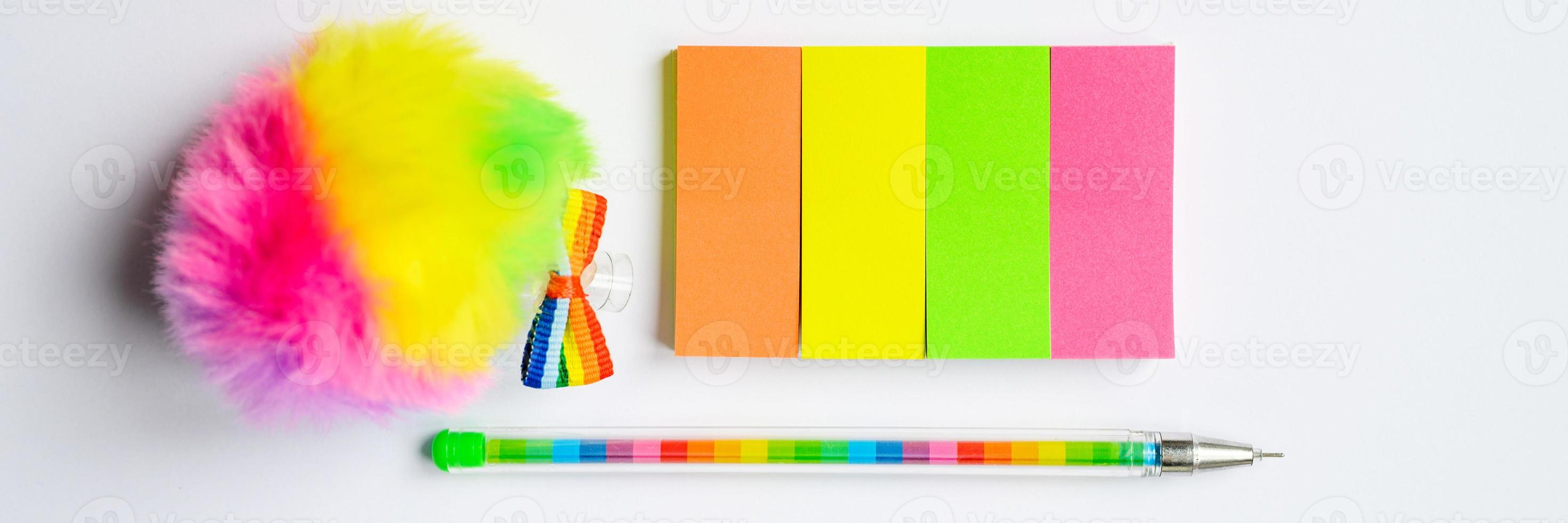 Multi-colored stickers and a pen on white background photo