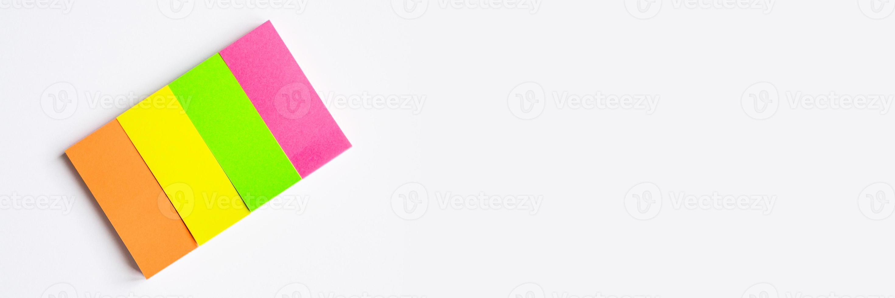 Multi-colored stationary notes on white background photo