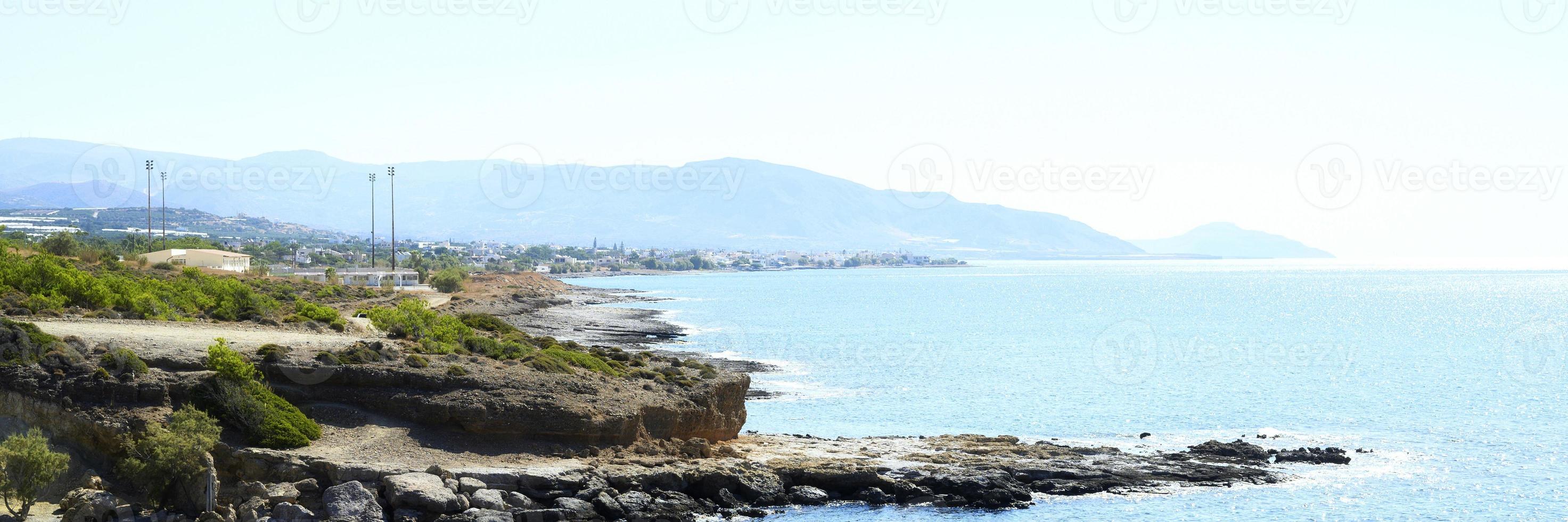 Beautiful blue lagoon with clear sea water and a pebble beach and rocks photo