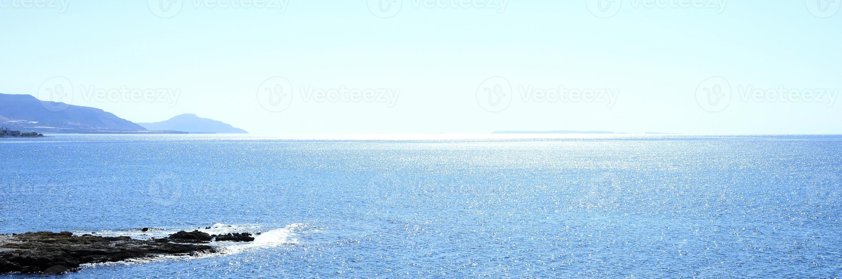 Seascape with mountains and rocks at dawn, beautiful blue water and sky photo